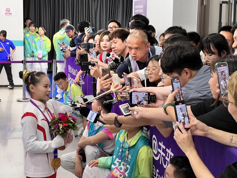 广电记者在混合采访区采访体操团体夺冠的宁波小将张欣怡.jpg